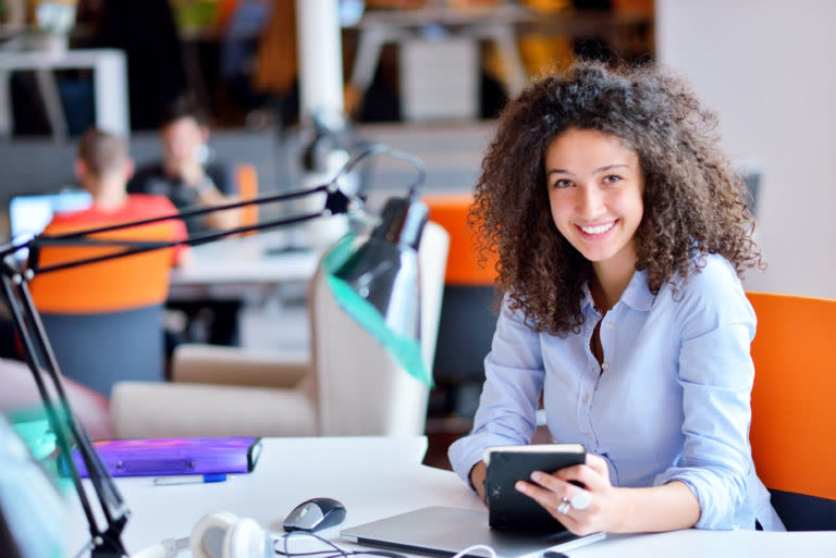 Portrait d’Ana, créatrice d’entreprise, souriante à son bureau.